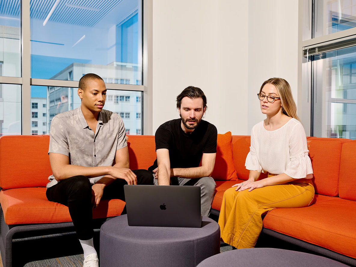 A photo of a team discussing work around a table